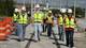 Students take in a construction Mass Electric construction site on tracks of Houston’s Metrorail system.